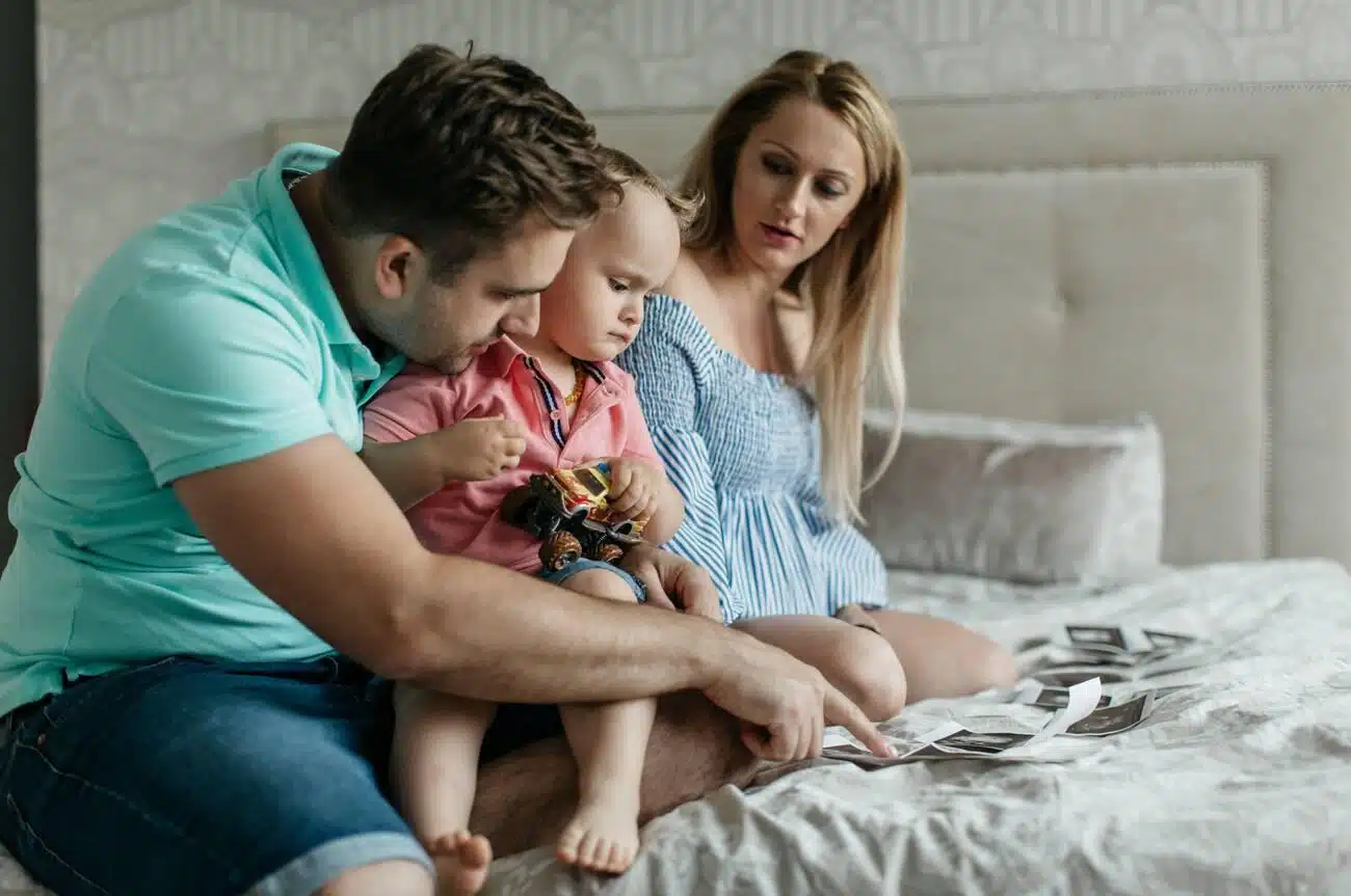 A pregnant woman with her partner preparing their child for a new sibling.