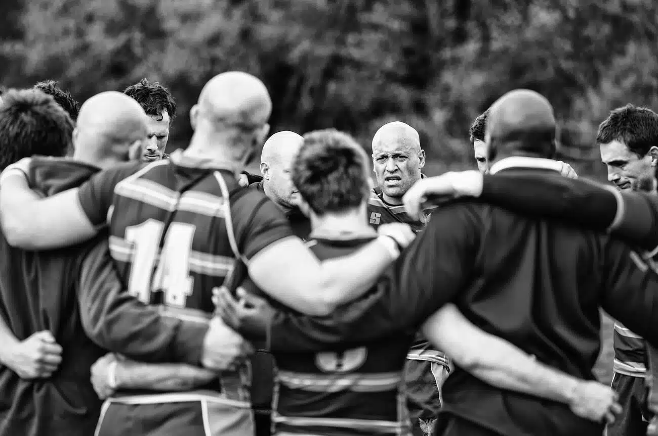 Rugby players huddle after a victorious match