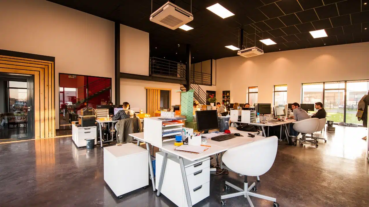 People sitting on chairs beside their desks in a temporary office space