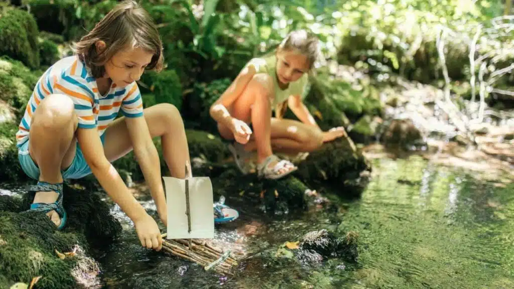 Children playing with boat on river