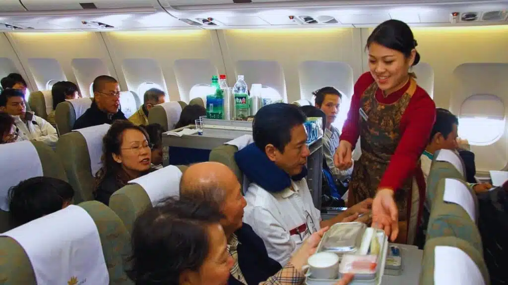Vietnamese flight attendants serve food and drink to passengers on a Boeing airliner in Vietnam