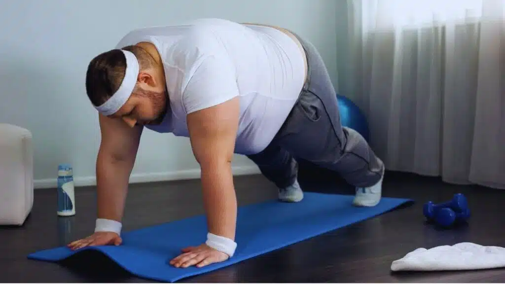Fat male trying to do push up exercise at home