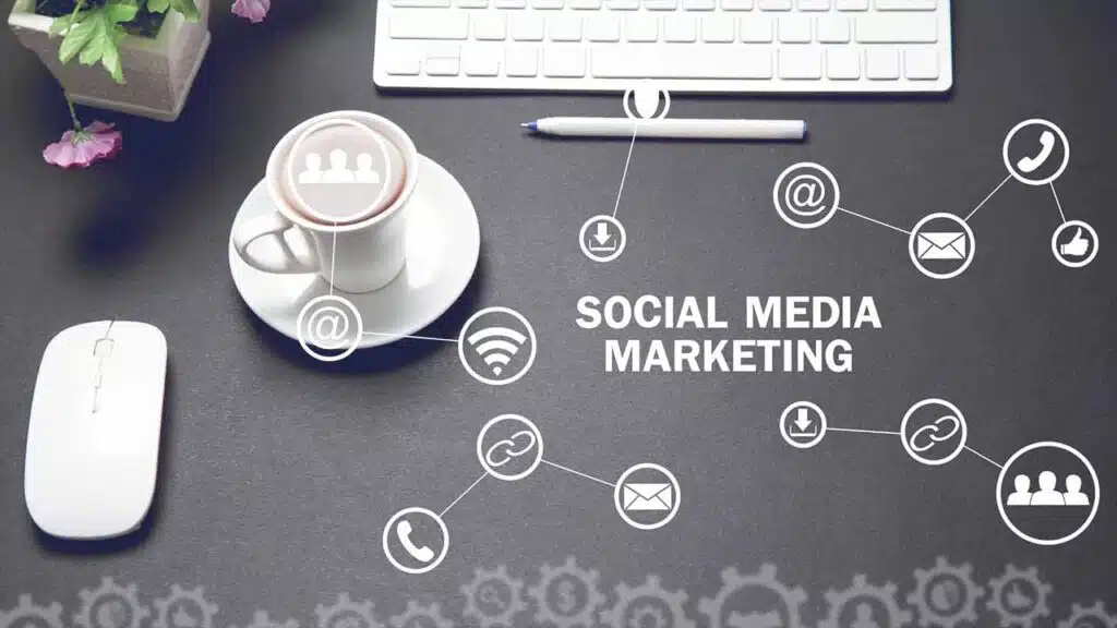 Desk with a keyboard, mouse, coffee cup, and social media marketing icons