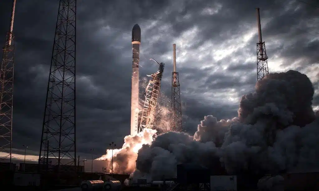 Rocket launching amidst dark, cloudy skies with smoke billowing around