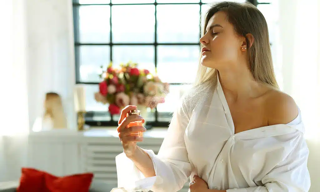 Woman in a white shirt applying Aquatic perfume