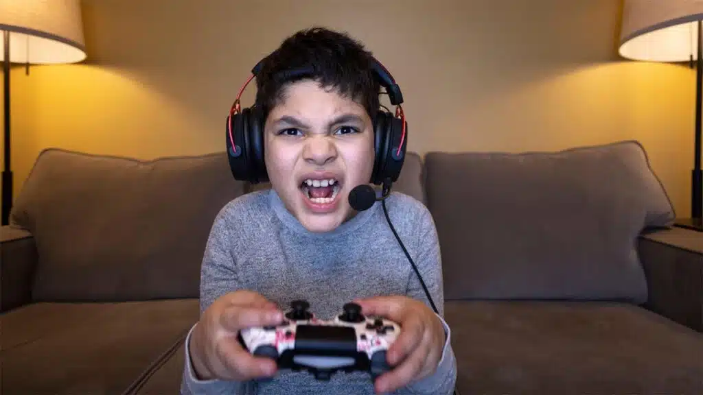 Child intensely focused on gaming with a controller and headset.