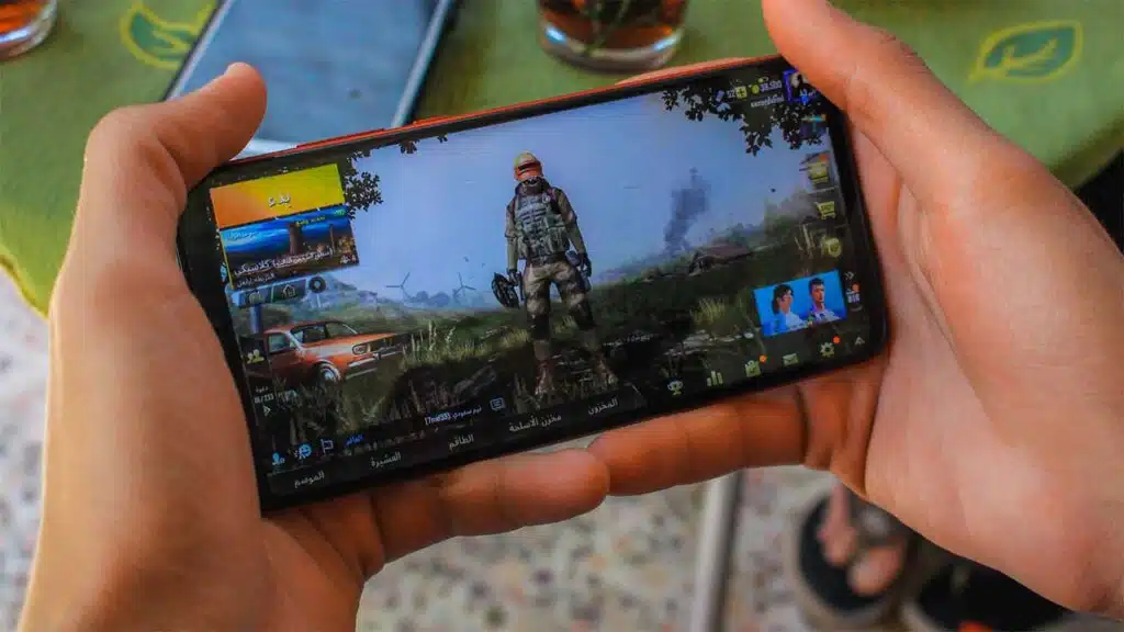 Person playing a battle royale game on a smartphone.