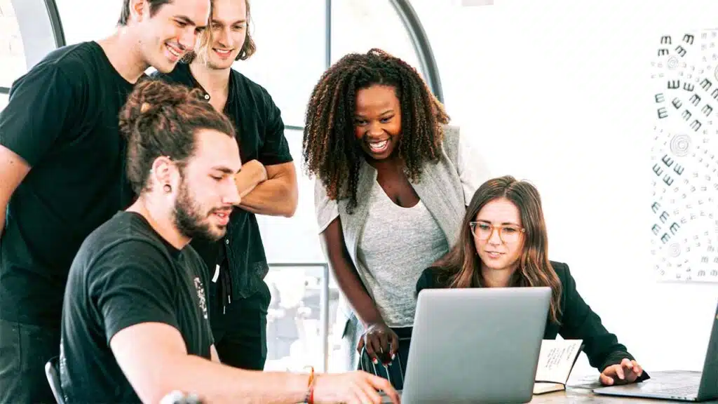 Group of young professionals collaborating on a laptop.