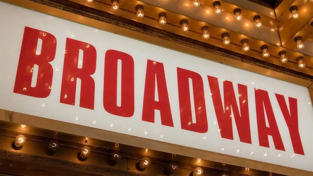 Broadway theater marquee sign lit up with bulbs.