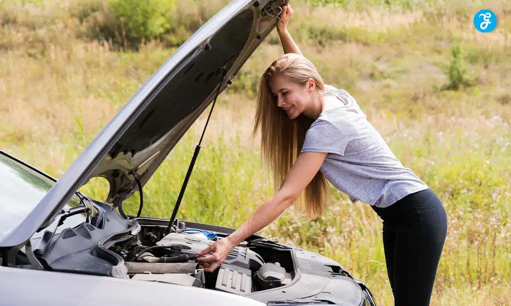Young woman checking her car engine outdoors.