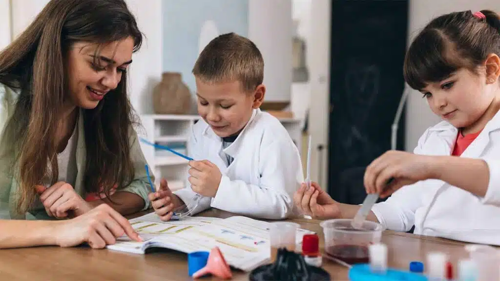Teacher guiding children in a science experiment.