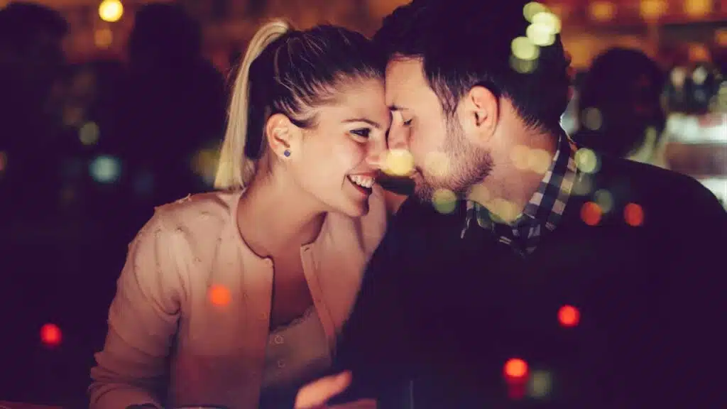 A couple smiling and leaning in close