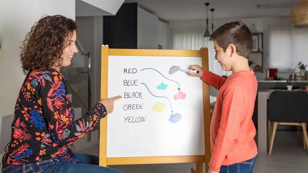 Mother and son learning colors on a whiteboard.