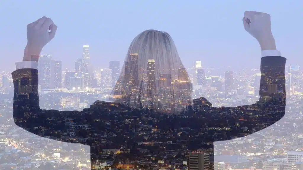 Double exposure of a confident woman and a city skyline at dusk.