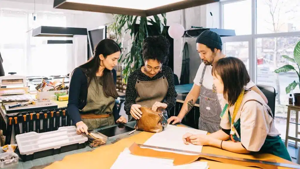 Team of artisans working on a leather project in a workshop