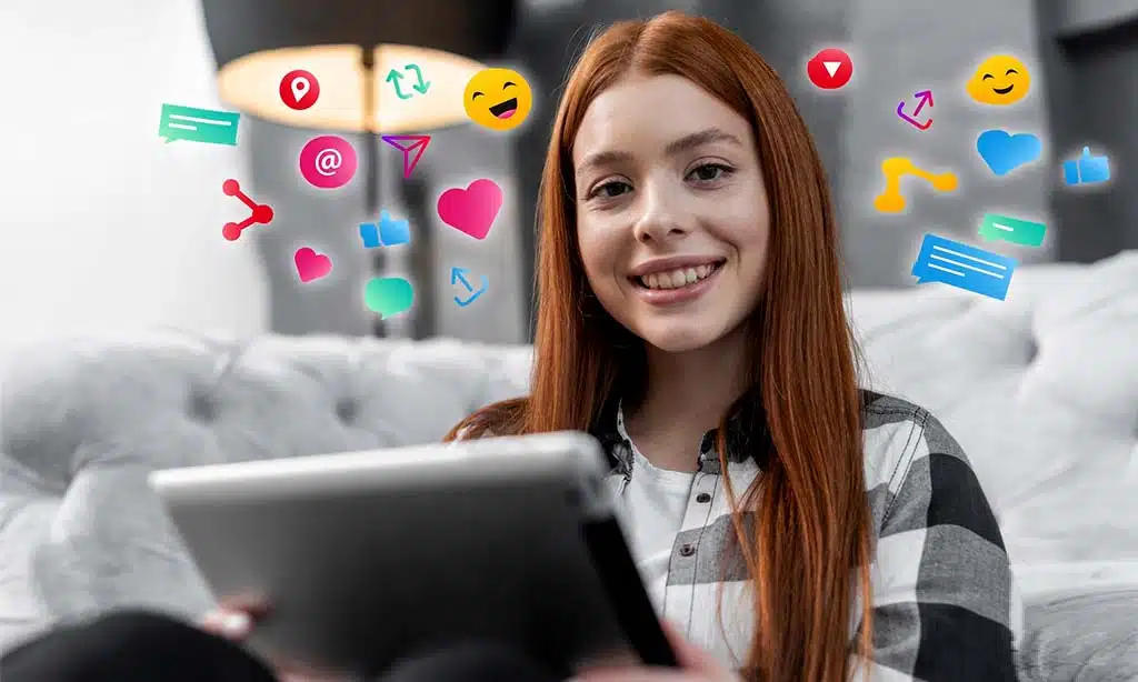 Smiling woman using a tablet with social media icons around her.