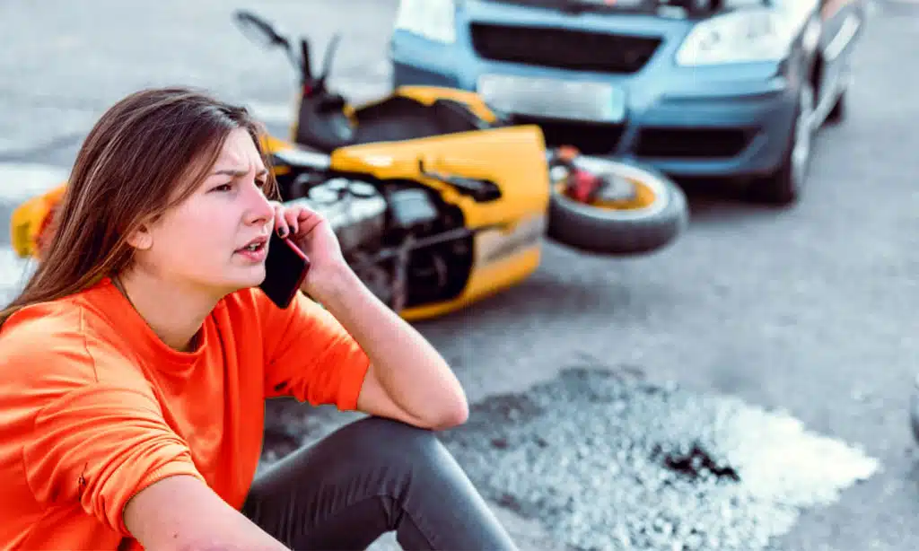 Woman calling for help after a motorcycle accident.