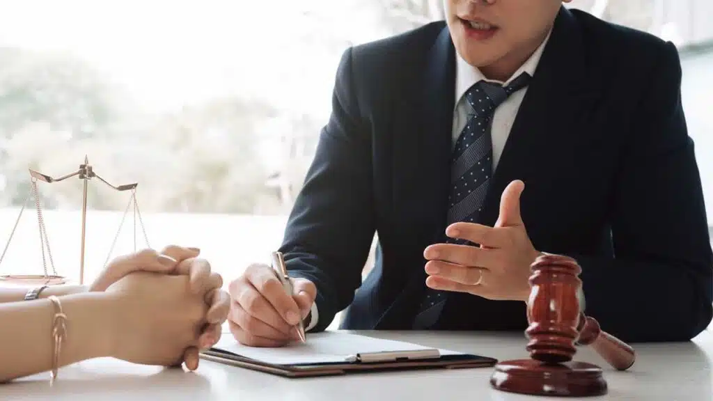 Lawyer advising a client with legal documents on the desk.