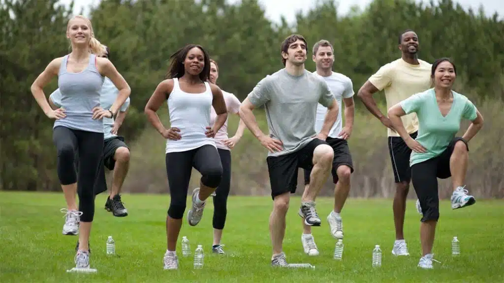 Group fitness class exercising outdoors.
