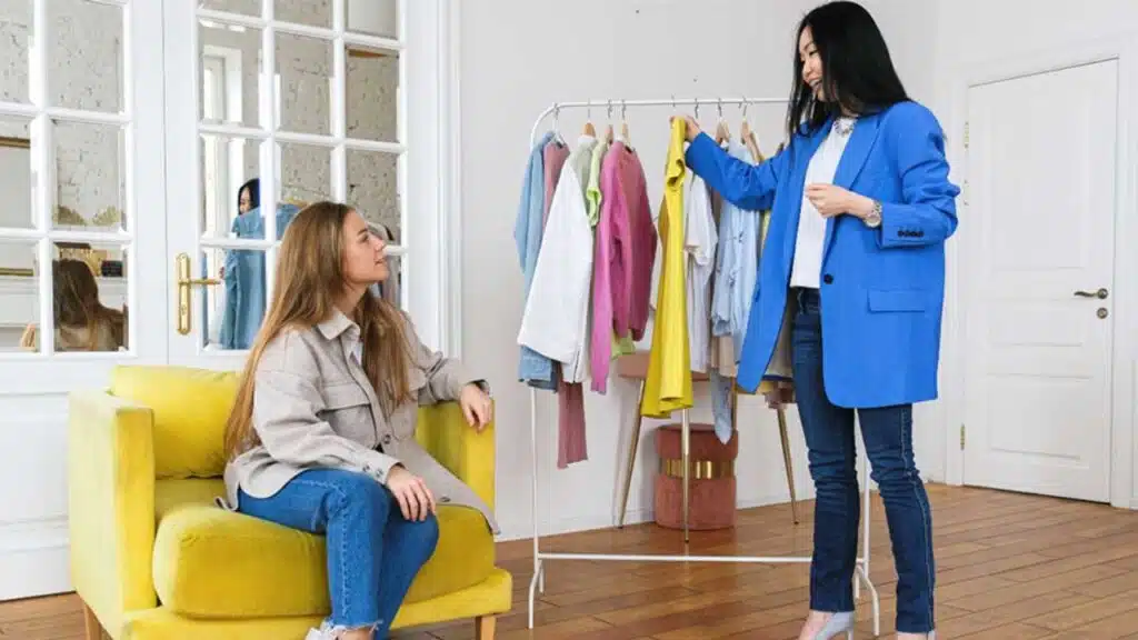 Two women discussing clothing options in a stylish room
