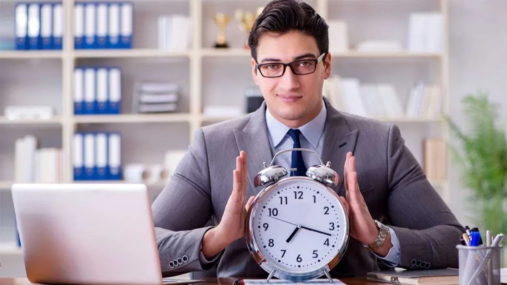 Businessman with clock focusing on time management.