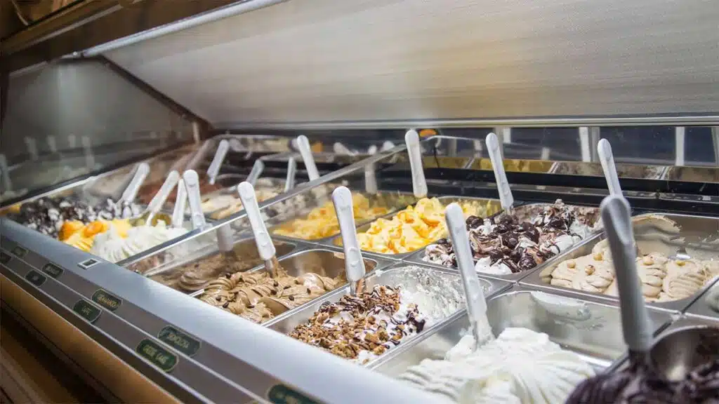 A variety of gelato flavors in a display case at an ice cream shop.