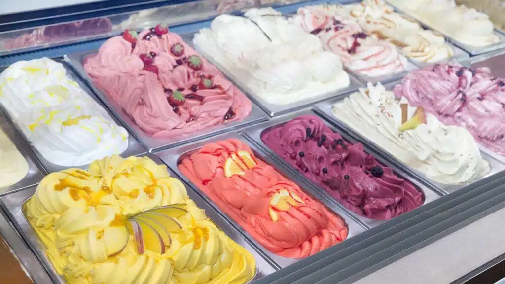 Colorful assortment of gelato flavors in a display case.