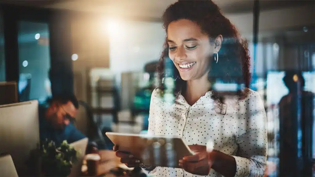Smiling professional using a tablet in a modern office.