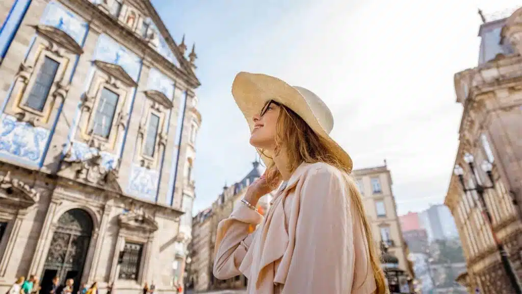 Tourist woman in a hat admiring historic architecture.