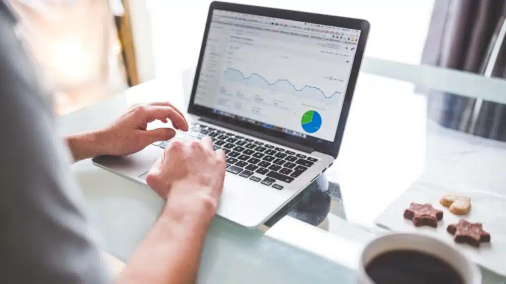 Person working on a laptop analyzing data charts
