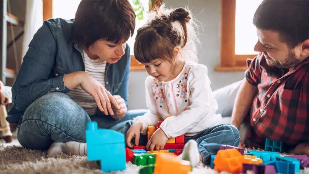 Parents playing with their daughter and toys at home