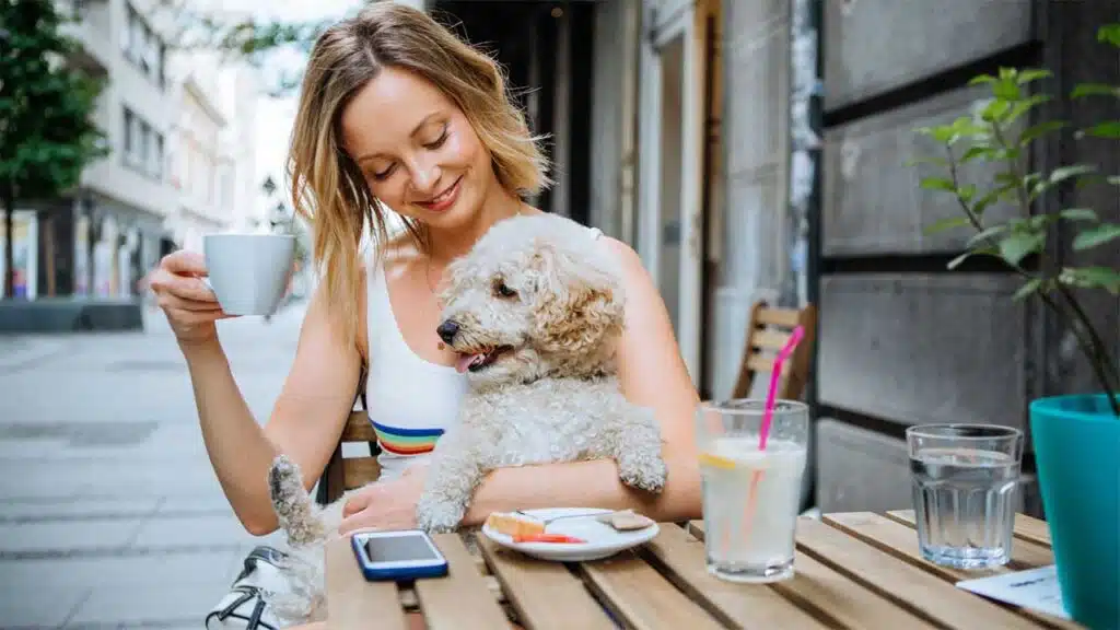 Enjoying coffee with a pet dog at an outdoor café.