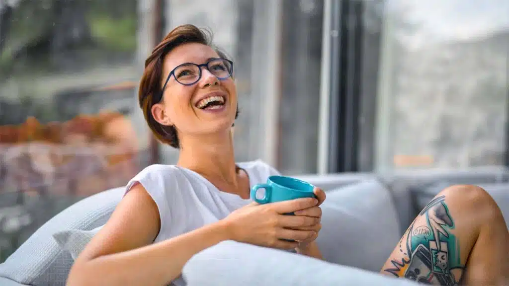 Smiling Woman Relaxing Indoors with Coffee Mug