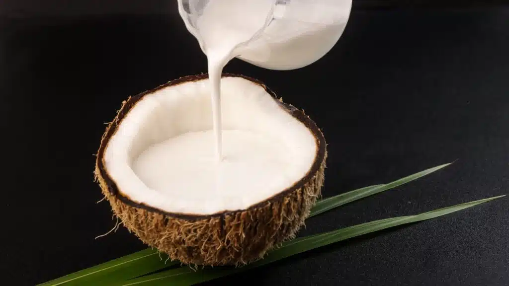 A half coconut shell filled with coconut milk