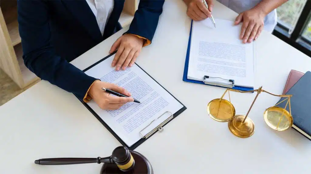 Two professionals in a formal legal setting reviewing documents