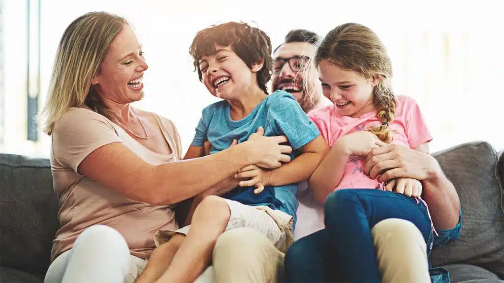 Happy Family Laughing and Bonding Together on a Couch