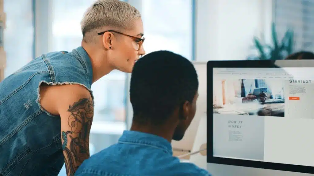 Two colleagues are working together on a project at a computer