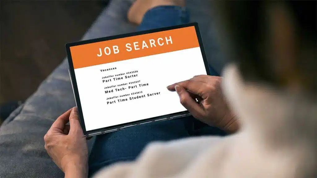 person holding a tablet while browsing through a job search page