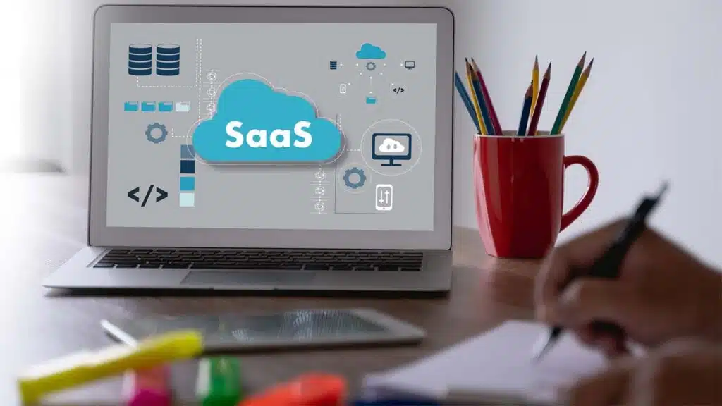 Person working on a laptop displaying SaaS cloud technology icons