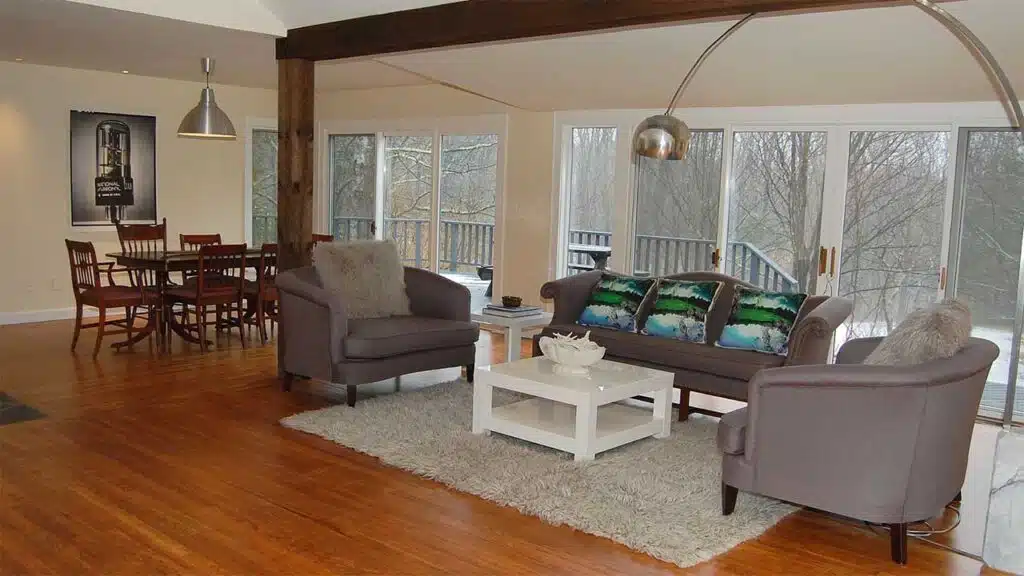 Spacious modern living and dining area with large windows overlooking nature