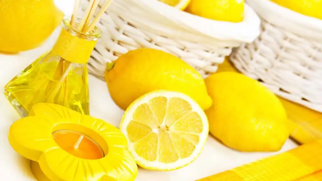 Fresh lemons with a lemon-scented candle and diffuser, creating a bright and refreshing ambiance.