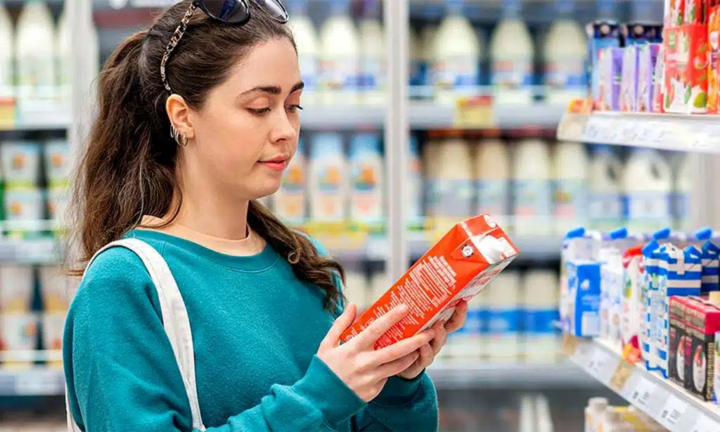 Woman reading a product label while shopping in a grocery store