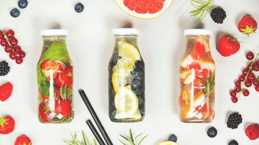 Three glass bottles filled with fruit-infused water