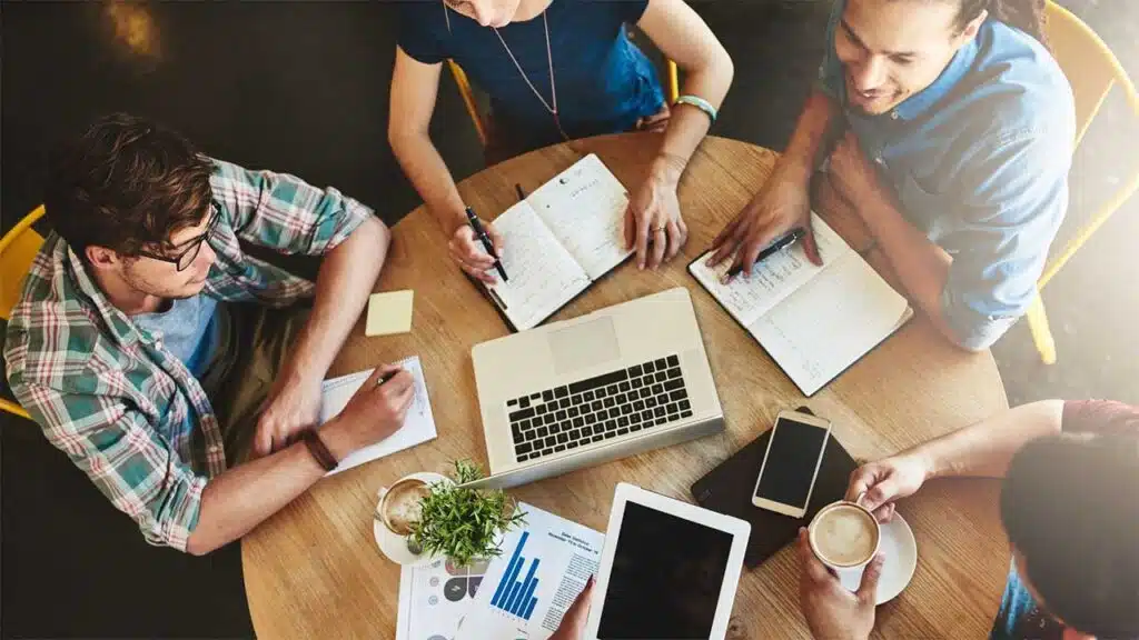 Group of four people sitting around a wooden table