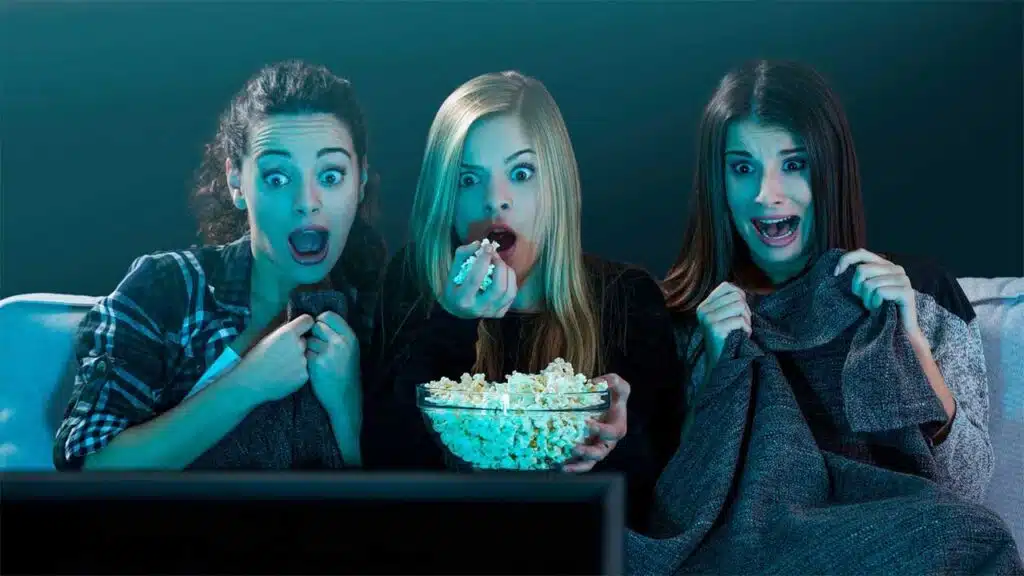 Three women watching a scary movie together