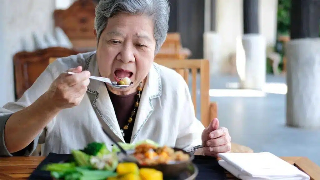 Senior woman enjoying a healthy meal at a dining table
