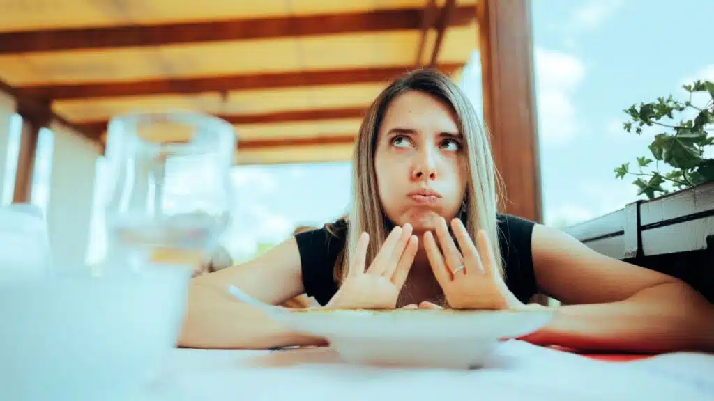 She has her cheeks puffed out, with her hands raised slightly in front of her.