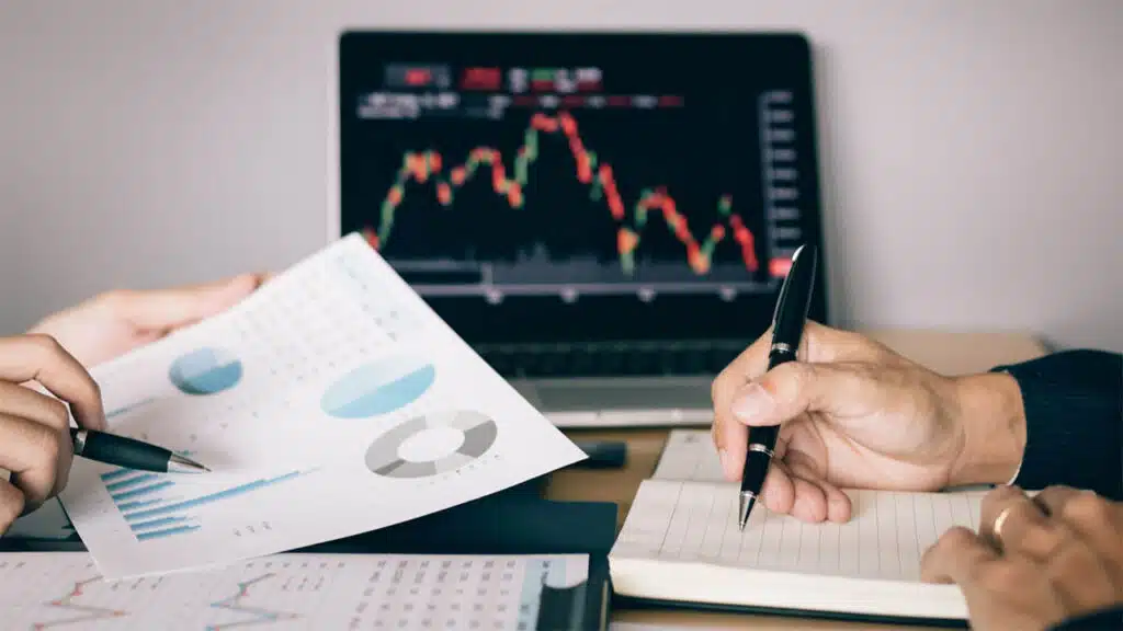 Two people analyzing financial charts and graphs