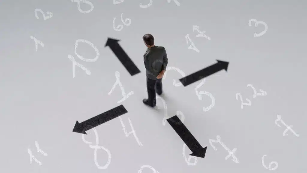 Man standing at crossroads with arrows pointing in different directions