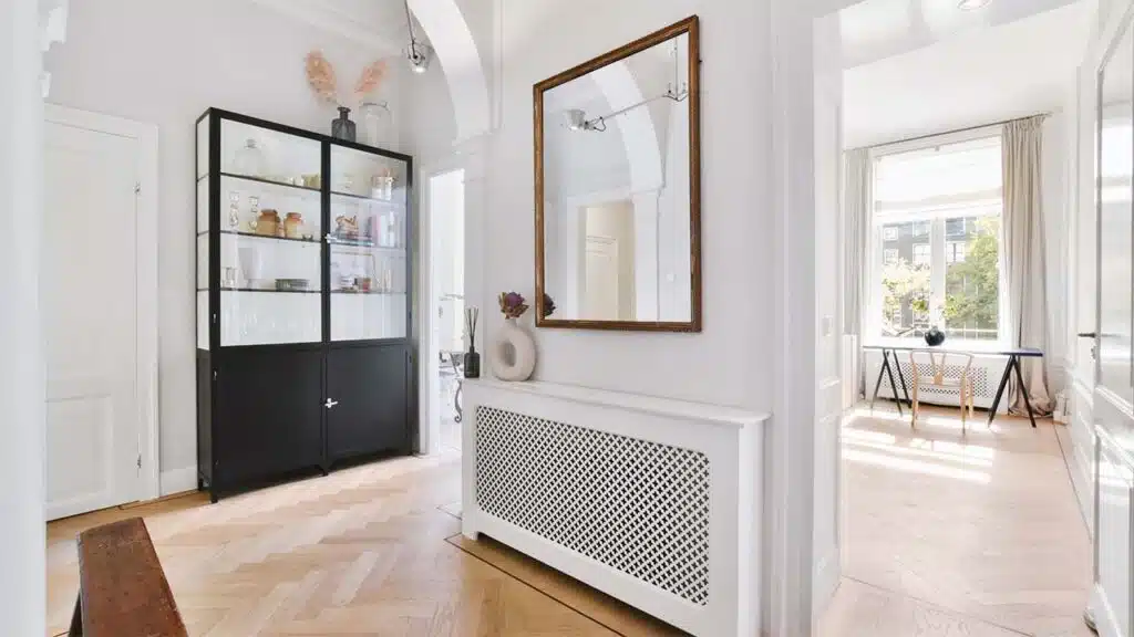 A bright and modern hallway with light wooden floors and white walls, creating an airy atmosphere